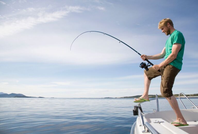 Fisher man holding his fishing rod with a catch.