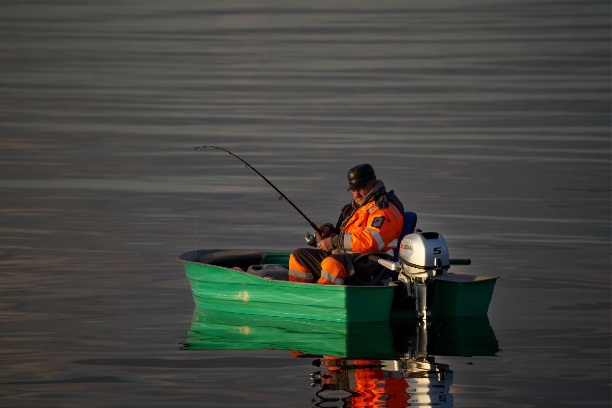 A man enjoying boat fishing in the lake.