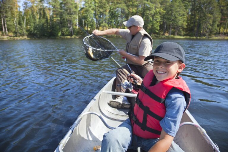 Father and son on a small boat fishing.
