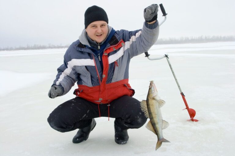 A man holding a catch on an ice fishing.